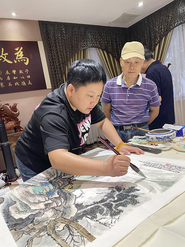 恩师华夏国艺书画艺术中心副主任、中企报盟信息科学研究院副院长高健林在小型创作研讨会上欣赏学生华夏国艺书画艺术中心会员、特聘书画家罗敏创作.jpg
