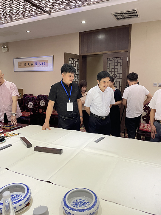 华夏国艺书画艺术中心会员、中企报盟信息科学研究院研究员张春根与中国文联办公厅主任、中国民族建筑研究会书画艺术专业委员会主任罗杨在笔会现场交流互动.jpg
